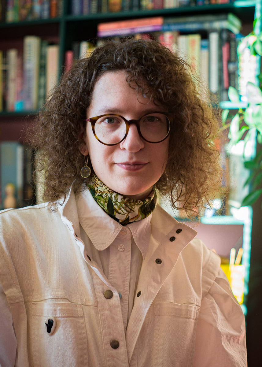 Robin Mientjes, the proprietor of Tiny Type Co, in front of some bookshelves and plants, with a slight grin. Photo by Nina Amen.